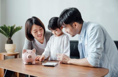 parents teaching daughter to save money at home