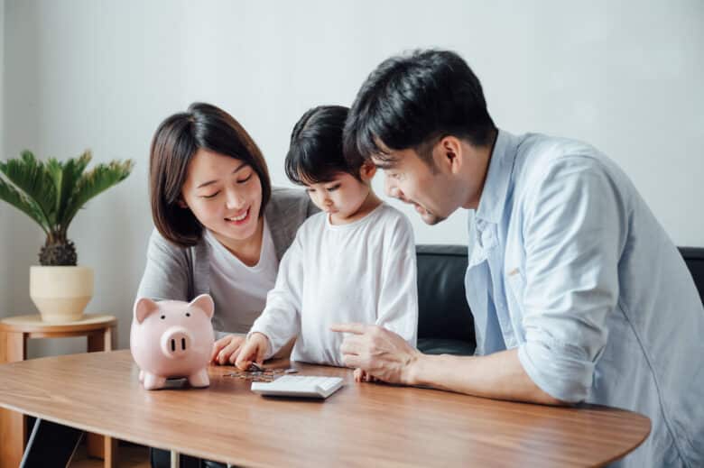 parents teaching daughter to save money at home
