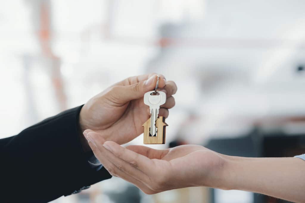 couple receiving key with house shaped keychain and preparing for property trust