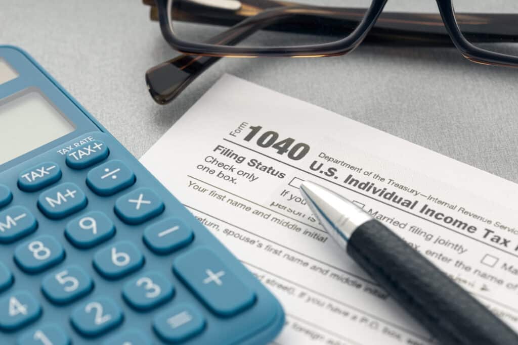 tax concept. tax form, calculator, eyeglasses and pen on table