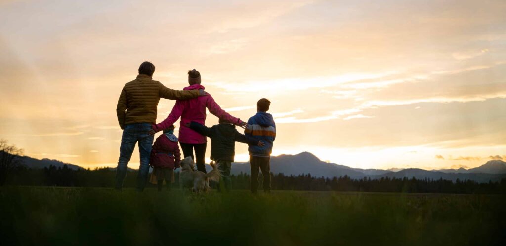 family of five having fun outside at dusk