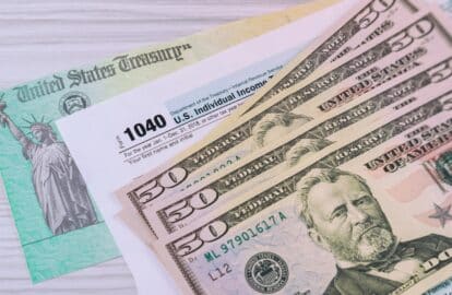 a us federal tax 1040 income tax form with money and refund check