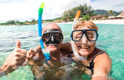 senior happy couple taking selfie in tropical sea excursion with