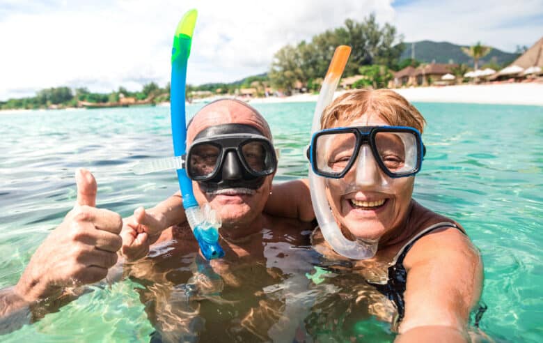 senior happy couple taking selfie in tropical sea excursion with