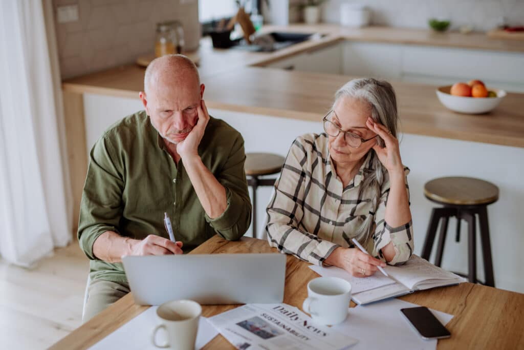 stressed senior couple calculate expenses or planning budget together at home.