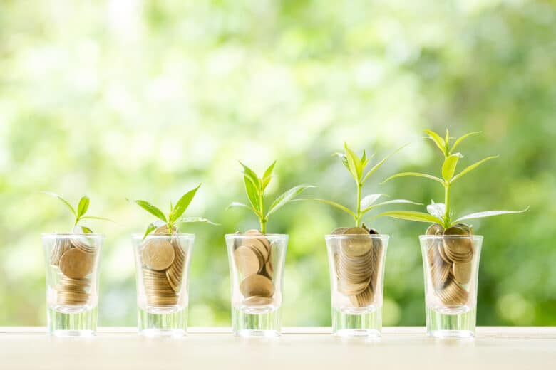 coin on wooden table in front of green bokeh background.