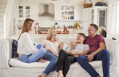 family with teenage children relaxing on sofa together