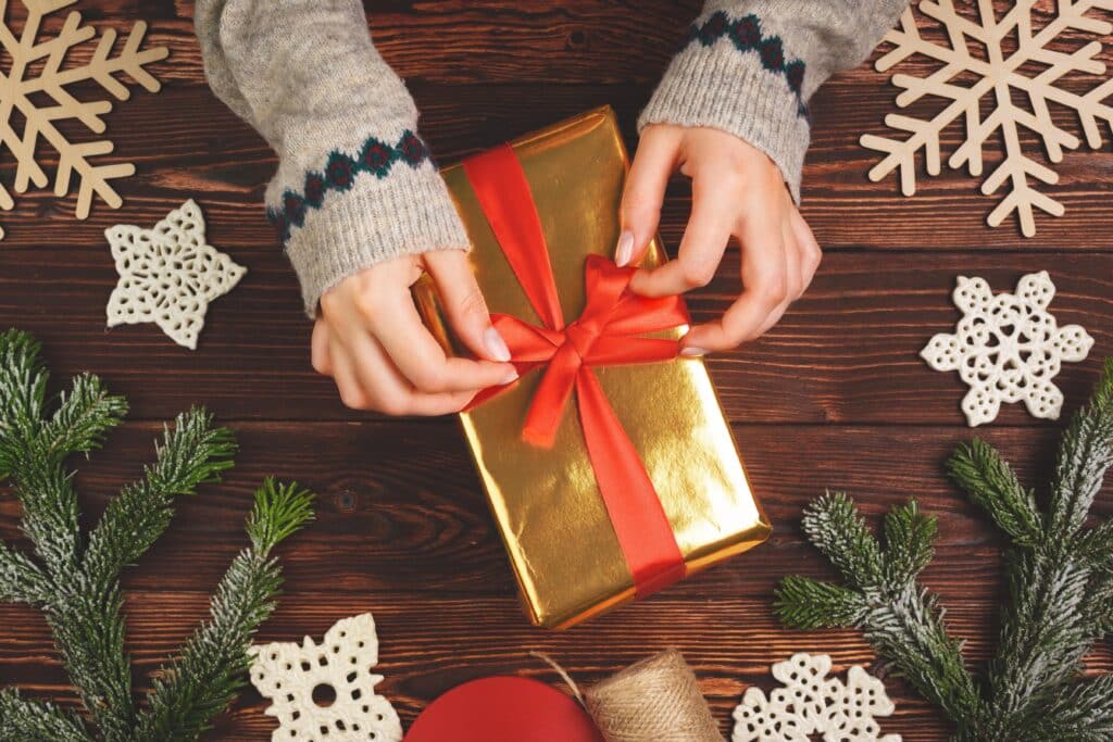 woman holding wrapped christmas present in her han 2023 11 27 04 54 57 utc min